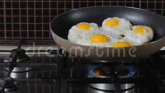 女人在煎锅上摇着皱巴巴的鸡蛋视频的预览图