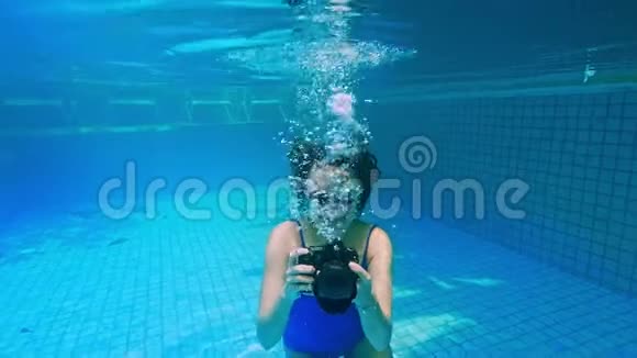 年轻女子潜入水中从水下看喷雾暑假概念跳到游泳池女孩视频的预览图