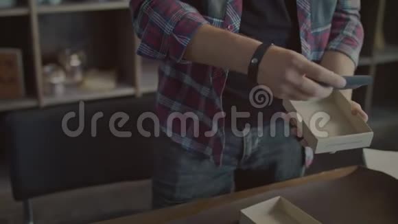 小型零售店用纸箱包装的男性手包装产品视频的预览图