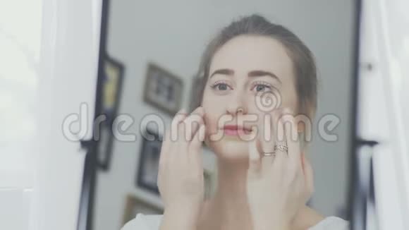 女人脸上戴着奶油或化妆面具的肖像视频的预览图