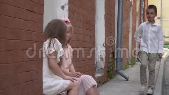 小男孩在房子之间的街道上靠近女孩视频的预览图