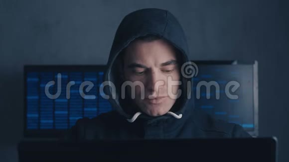 一个被通缉的黑客在黑暗的办公室里用电脑视频的预览图