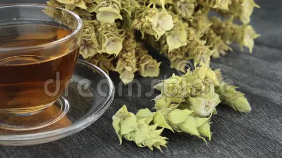 一大堆山茶马洛提拉和杯子与温暖的茶希腊传统草药透明杯希腊山茶视频的预览图