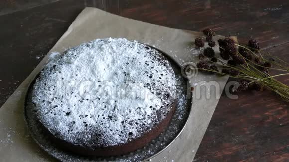 自制的新鲜烤巧克力巧克力饼粉末加糖糖位于时尚的干草地花旁边视频的预览图