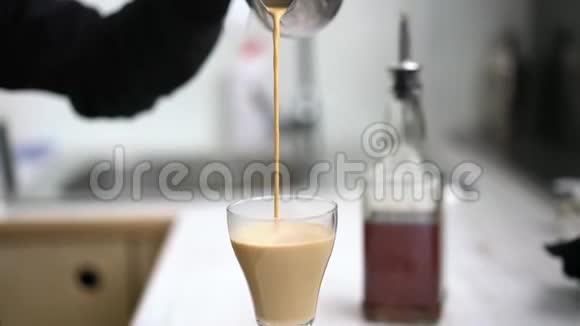 咖啡师把咖啡和牛奶倒入玻璃杯中视频的预览图