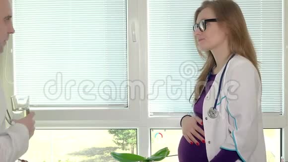 同事医生给孕妇一片药丸和一杯水视频的预览图