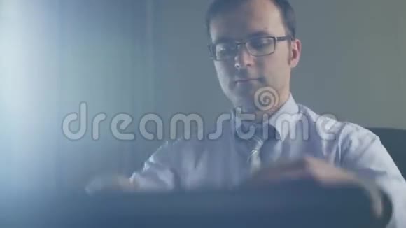 晚上坐在笔记本电脑前的商人视频的预览图