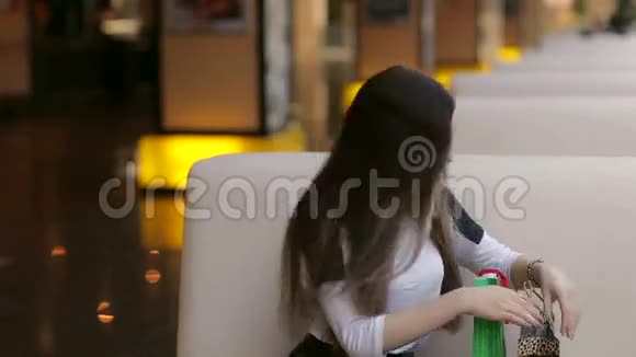 女孩看着她在购物中心的购物袋视频的预览图