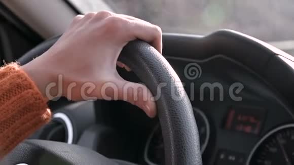 一只穿着橙色毛衣的雌性手在城外开着一辆车开车的女人视频的预览图
