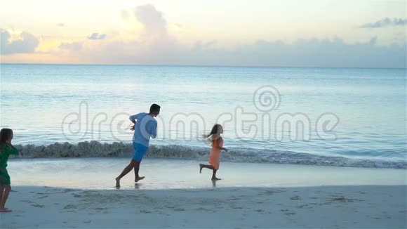 一家人在日落时在海滩上玩得很开心流动人口视频的预览图