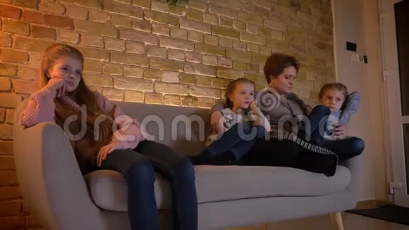 高加索母女的家庭肖像在舒适的家庭氛围中看电影视频的预览图