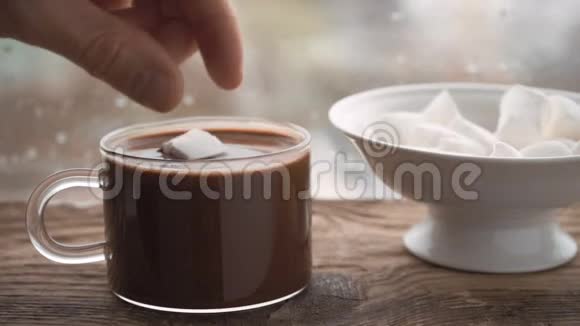 带可可和棉花糖的杯子窗台上有棉花糖的陶瓷碗视频的预览图