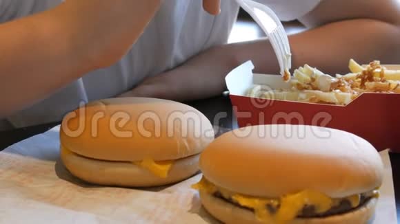 青少年正在吃洋葱和奶酪炸薯条用不健康的食物或快餐刺破塑料叉子视频的预览图