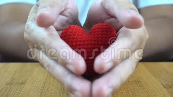 一双手捧着一颗红色的心视频的预览图