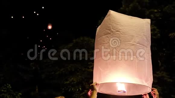 在义鹏节期间在洛伊克拉通庆祝活动中人们在夜空中点燃一盏大纸灯笼视频的预览图