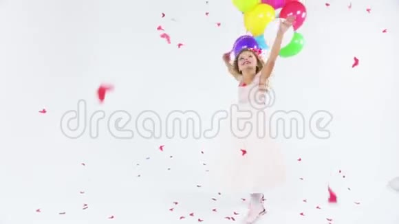 可爱的公主穿着粉红色的连衣裙有着美妙的发型头发上有花带着气球跳的迷人女孩视频的预览图