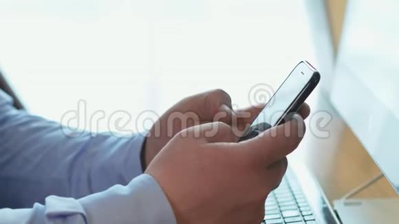 男子手在智能手机上滚动浏览商务办公室的社交网络视频的预览图