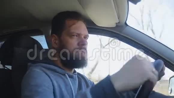 一个留着胡子的人坐在车里戴上太阳镜视频的预览图