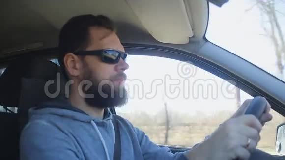 一个留胡子的人坐在车里摘下墨镜视频的预览图