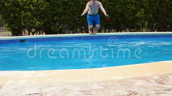 从热带岛屿酒店跳进游泳池的男人视频的预览图