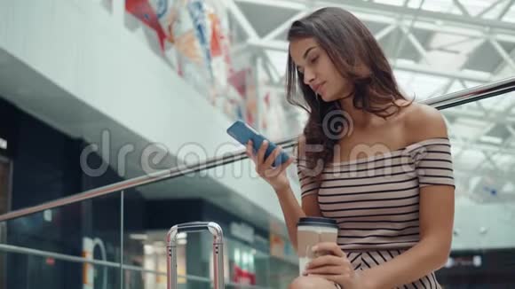 购物妇女微笑着拿着袋子在商场的电话里交谈带智能手机的漂亮女孩带着购物中心的行李视频的预览图