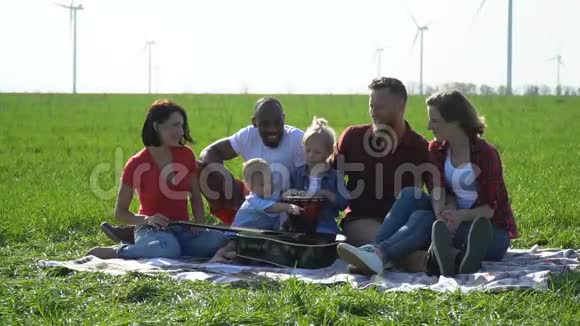 一群带着孩子的人在野餐时享受着美妙的天气视频的预览图