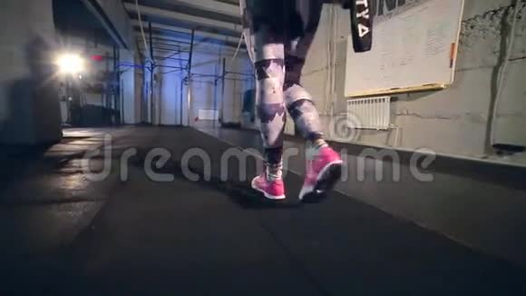 一个穿灰色紧身衣的女孩走进健身房脱下风衣视频的预览图