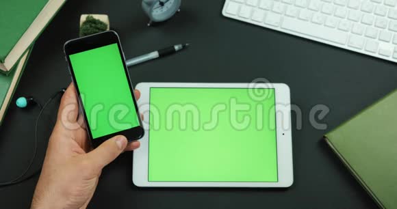 男人把眼镜放在桌旁桌上放着绿色的屏幕视频的预览图