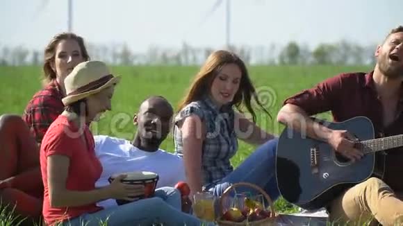 朋友们安排了一次野餐在绿色的草地上放歌和食物慢动作视频的预览图