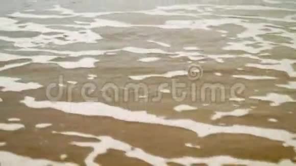 海水在海滩上膨胀时的泡沫景观视频的预览图