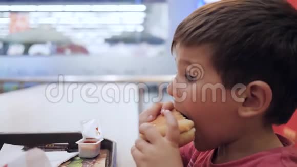 美味的食物孩子在桌子上玩有害的食物汉堡和薯条作为儿子的零食油性食物视频的预览图