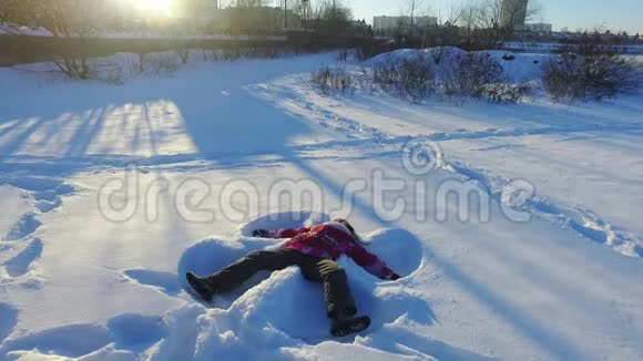 小女孩做雪天使冬季儿童假期视频的预览图
