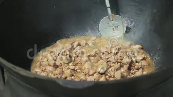 厨师用火炖的铁勺搅动肉视频的预览图