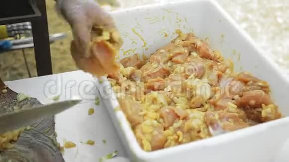 厨师手戴手套切洋葱腌制鸡肉视频的预览图