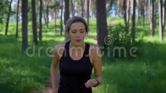 在夏季森林里的女运动员在路上奔跑的年轻女子视频的预览图