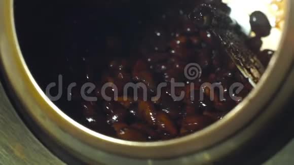 女人在釉里生产可可豆的机器里煎可可豆视频的预览图