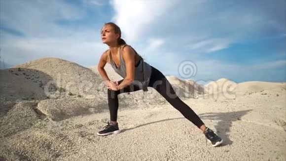 运动员在靠近沙滩的大自然中伸展腿部肌肉视频的预览图