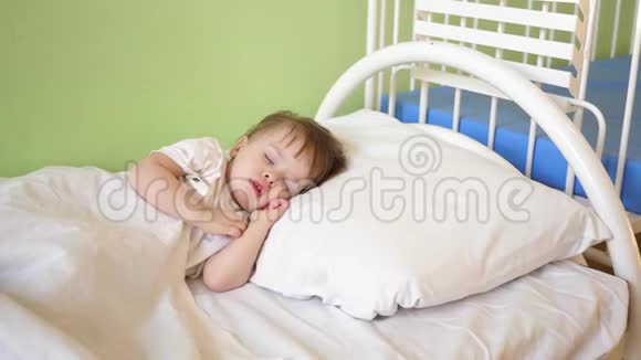 孩子睡在医院病房里睡觉孩子的概念迷人的婴儿在床上的白色床上睡着了视频的预览图
