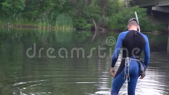 一个穿着潜水装备和面具的人站在河里视频的预览图