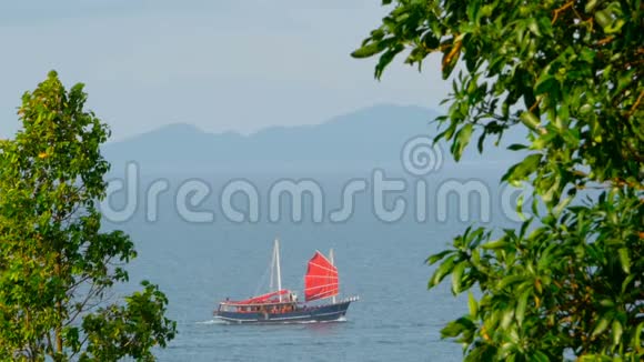 日落时分一艘中国传统的红帆船沿着大海漂浮视频的预览图
