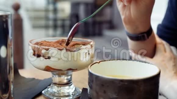 咖啡馆里的一个女人正在吃一个提拉米苏蛋糕视频的预览图