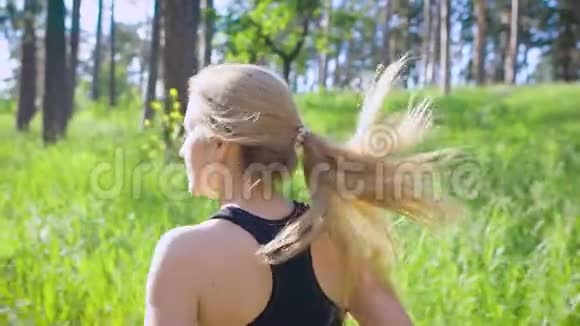 一位身穿运动服的金发年轻女子的慢镜头白天在公园里积极奔跑他很喜欢视频的预览图