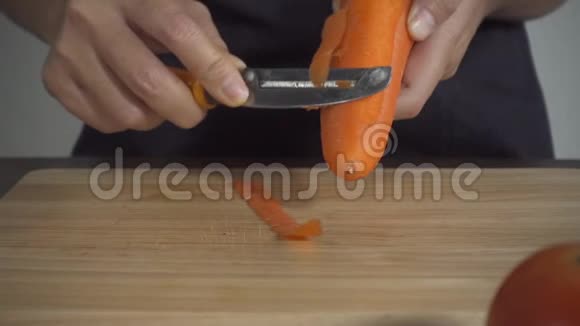 慢动作关闭妇女制作健康食品和切碎胡萝卜在切割板在厨房视频的预览图
