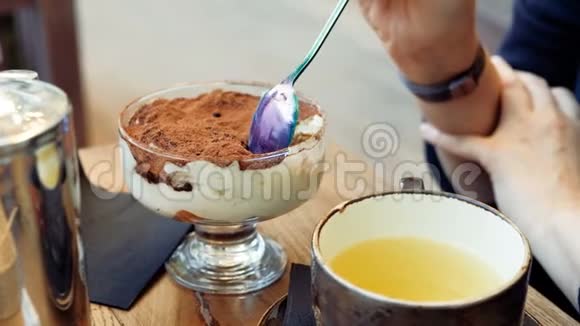 咖啡馆里的一个女人正在吃一个提拉米苏蛋糕视频的预览图
