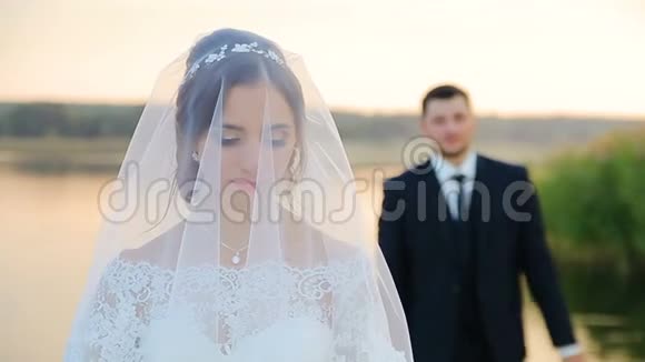 新娘和新郎拥抱在一个婚礼散步与湖视频的预览图