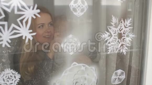 母亲和儿子用假雪装饰窗户视频的预览图