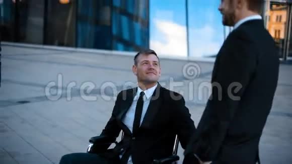 商务人士在户外玩得很开心在轮椅上无效视频的预览图
