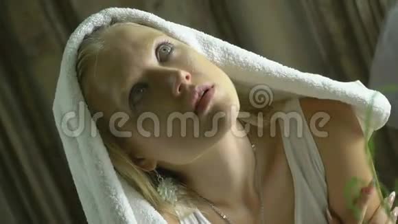 一个被毛巾覆盖的陌生女孩坐在房间里抬头看着视频的预览图