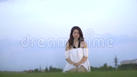 穿着白色裙子的日本悲伤女孩从膝盖上站起来动作缓慢视频的预览图