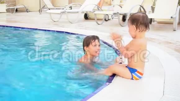 两个男孩弟弟在度假村的游泳池里洗澡视频的预览图